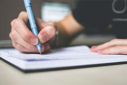 a-peron-writing-on-a-notebook